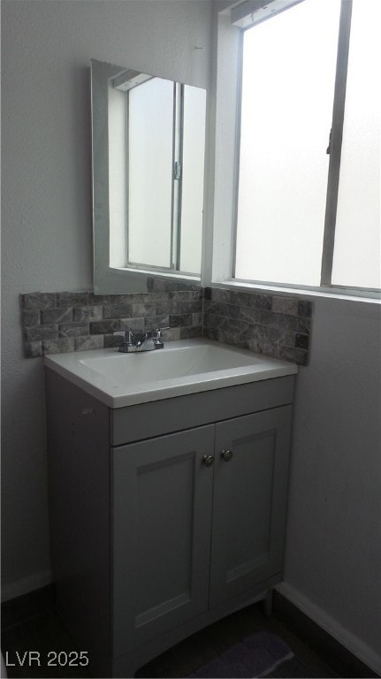 Bathroom featuring vanity and tasteful backsplash