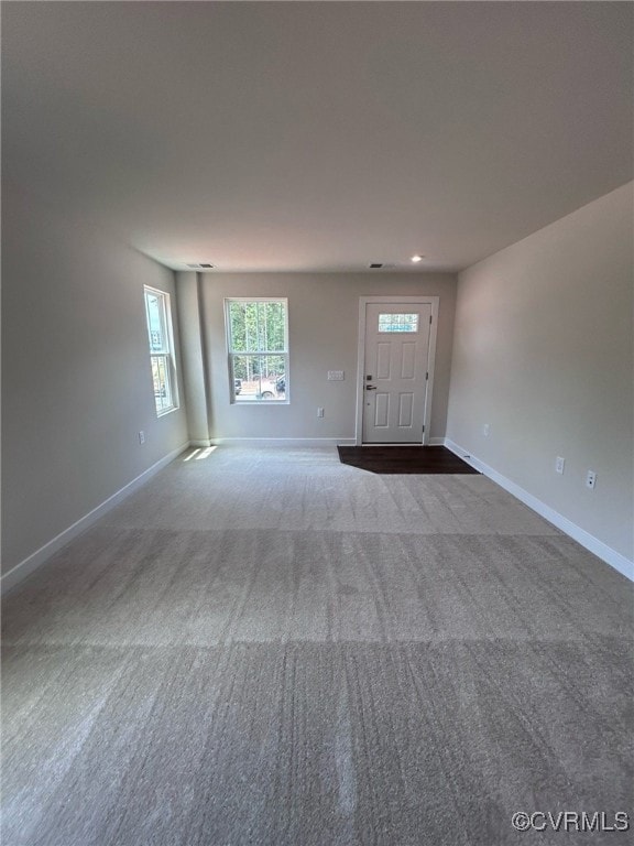 Carpeted foyer featuring baseboards
