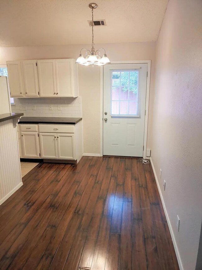 Doorway with dark wood-style flooring and a chand