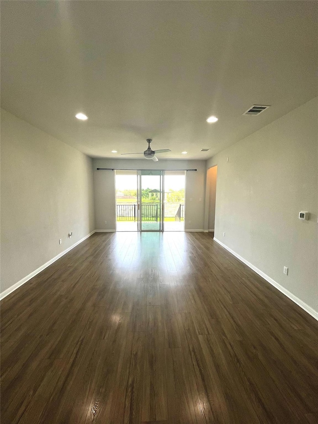 Spare room featuring ceiling fan, dark wood-style