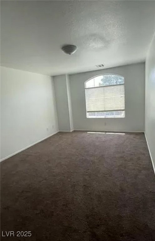Carpeted spare room with baseboards and a textured