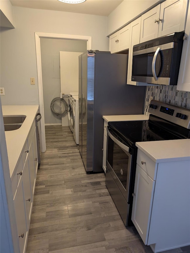 Kitchen with washer and dryer, wood finished floo