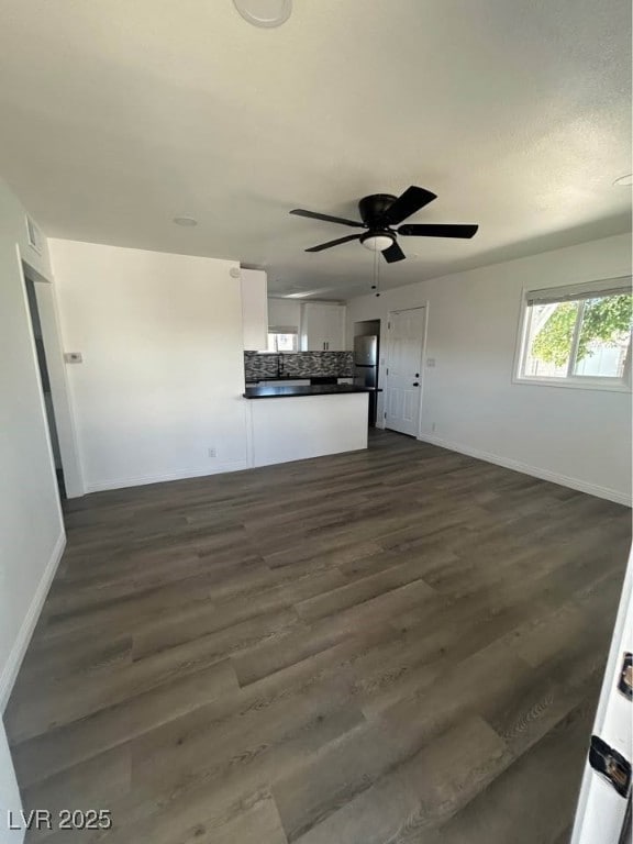 Unfurnished living room featuring baseboards, ceil