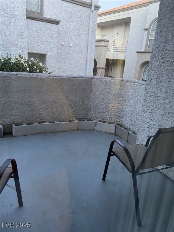 View of patio featuring a balcony