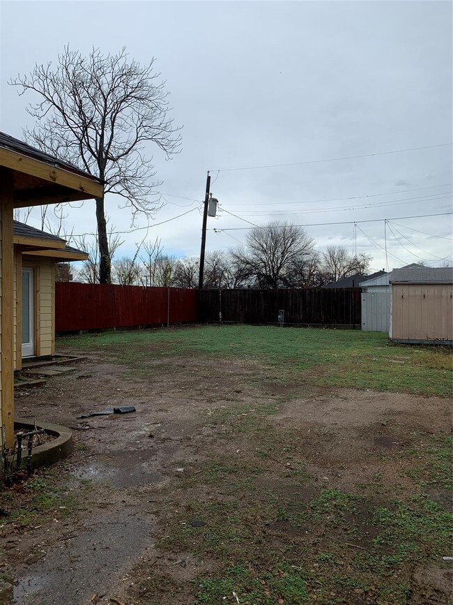Fenced back yard with storage building