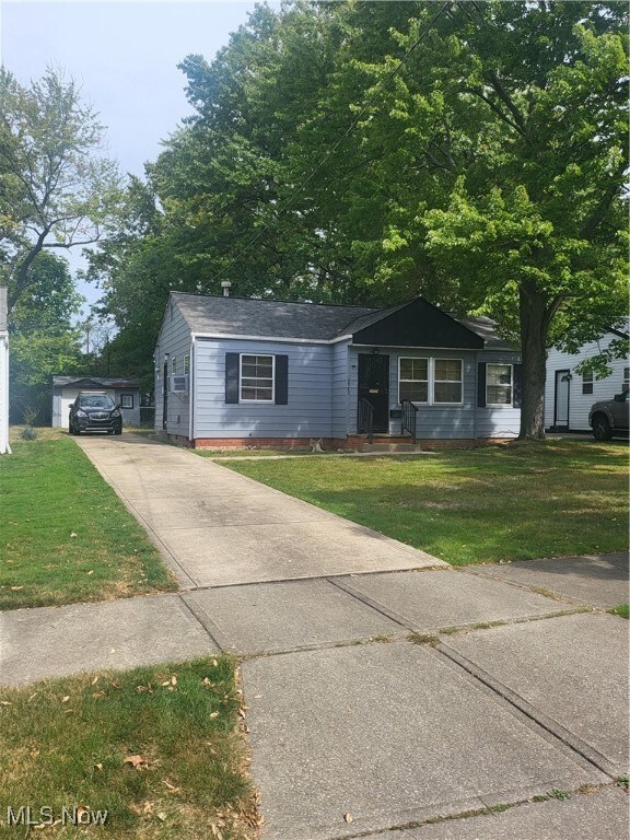 View of front of home featuring a front yard and a garage