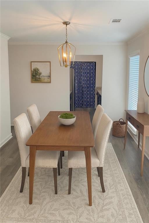 Dining room featuring crown molding, wood finished floors, and a chandelier