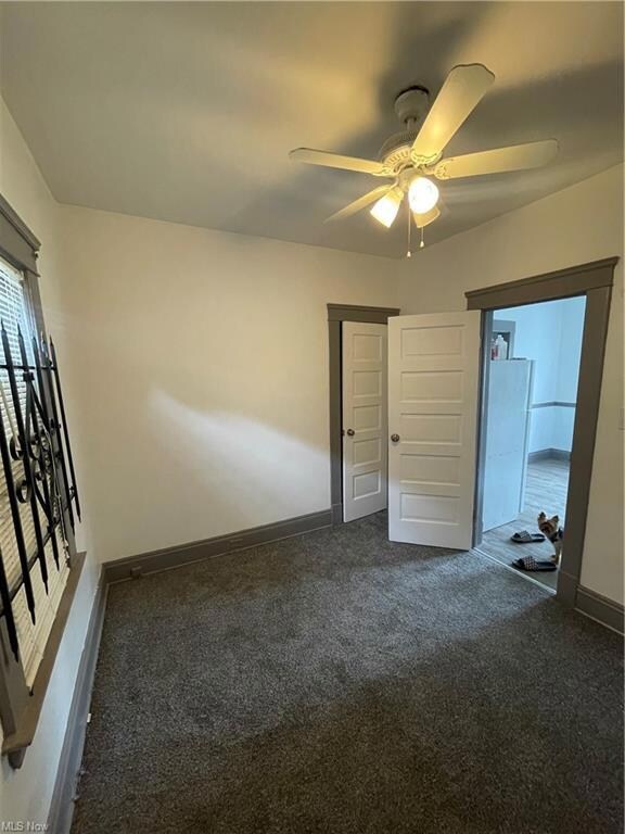 Spare room with ceiling fan and carpet flooring