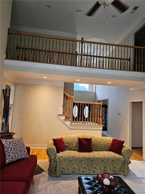 Living room featuring crown molding, ceiling fan, 