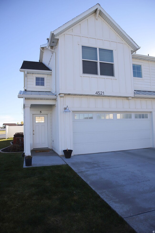View of front of house with board and batten siding, a garage, and concrete driveway