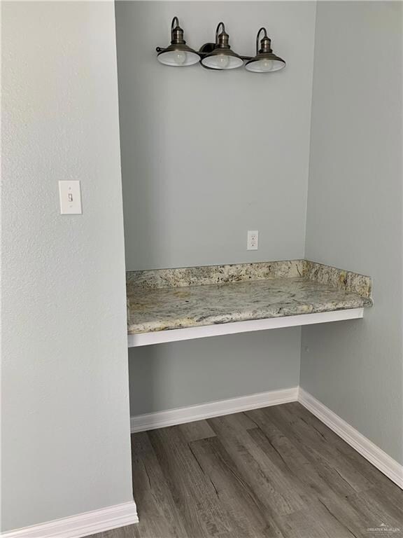 Bathroom featuring dark wood finished floors and baseboards
