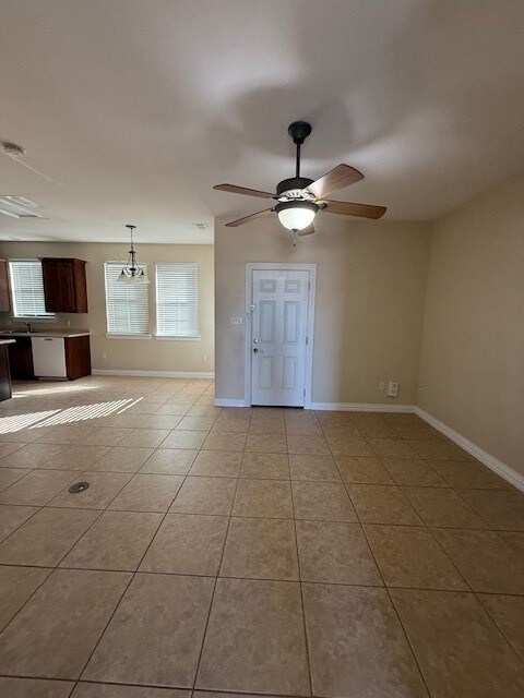 Unfurnished room with light tile patterned floors, ceiling fan, and a chandelier