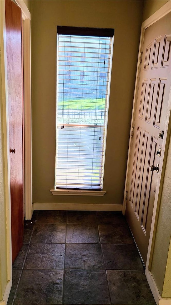 Doorway to outside featuring dark stone finish fl