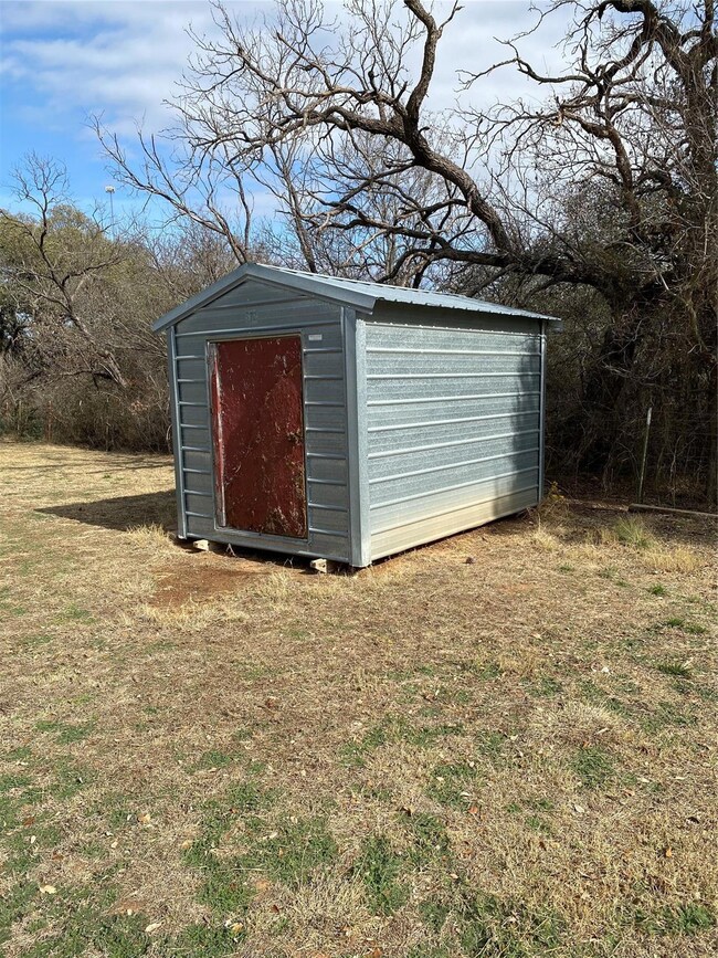 View of outbuilding with a yard