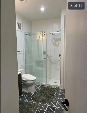 Full bath with a stall shower, toilet, vanity, an