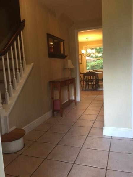 Foyer with ceramic tile flooring and half bath.