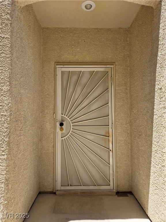 View of exterior entry featuring stucco siding