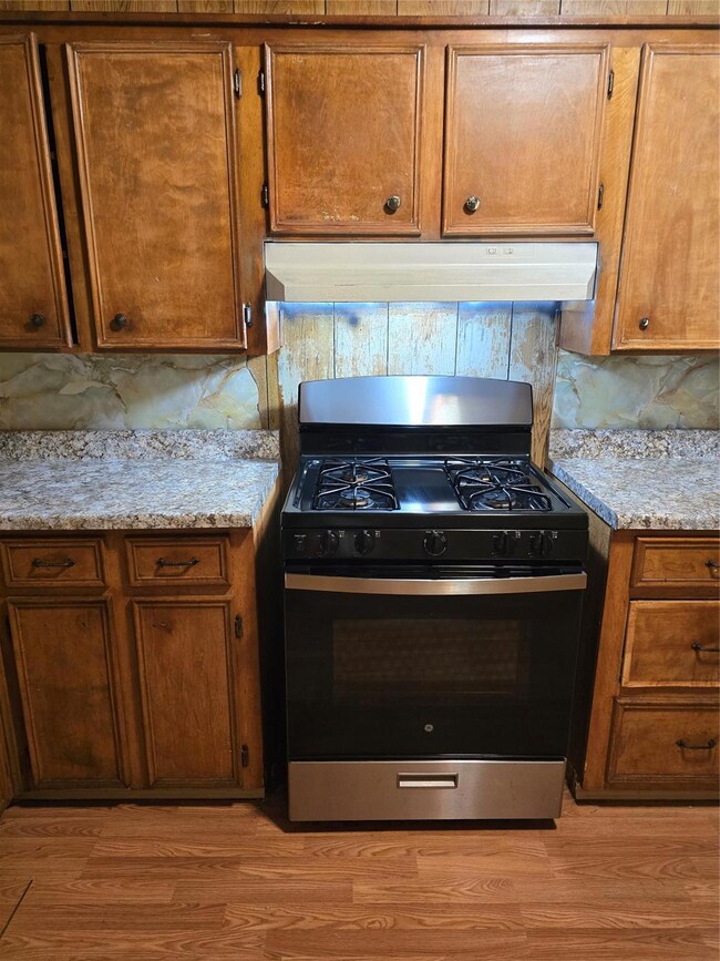 Kitchen featuring backsplash, range with gas stove