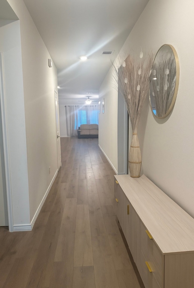 Hallway featuring dark wood-style floors and baseboards