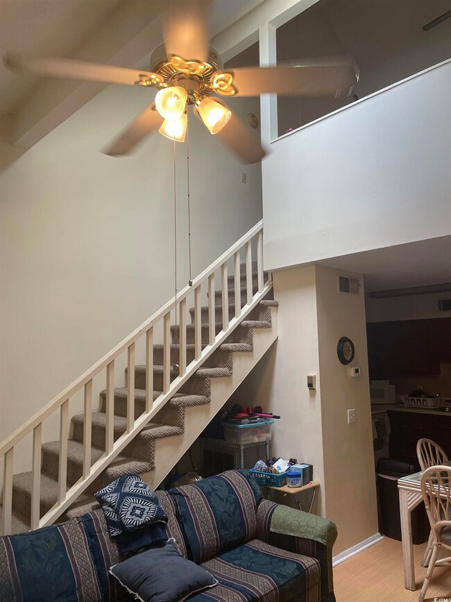 Stairway featuring ceiling fan and hardwood / wood