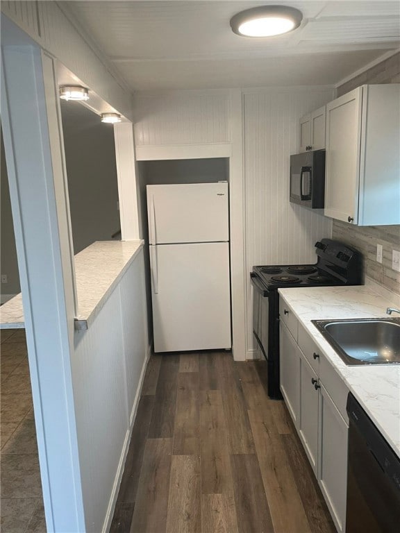 Kitchen featuring black appliances, light countertops, and dark wood-style floors