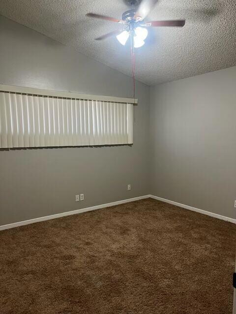 Empty room featuring a textured ceiling, a ceilin