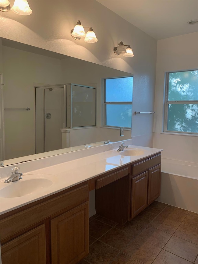 Full bathroom featuring double vanity, a shower s