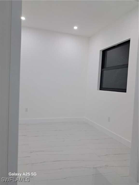 Empty room featuring marble look tile flooring, re