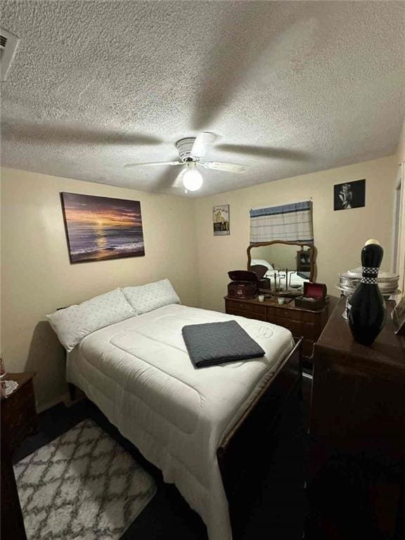 Bedroom featuring ceiling fan and a textured ceiling