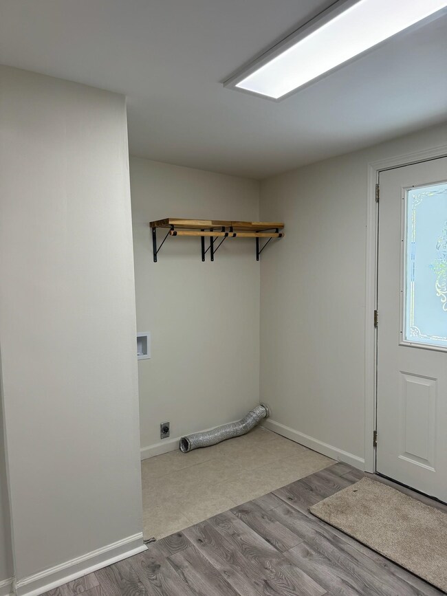 Laundry room featuring electric dryer hookup, wood finished floors, washer hookup, and baseboards