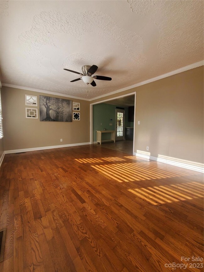 View of living room from front door, original hardwood floors, ornate ceiling