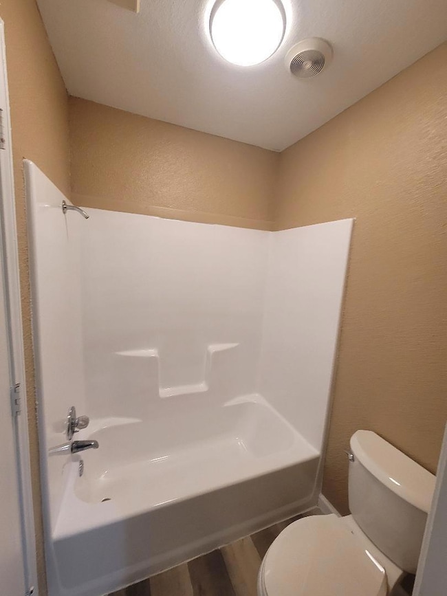 Full bath featuring a textured wall, visible vents