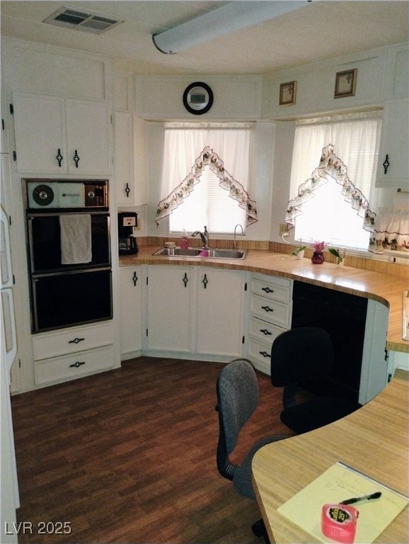 Kitchen with dark wood-style floors, white cabinet