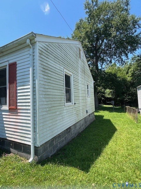 View of property exterior featuring a lawn