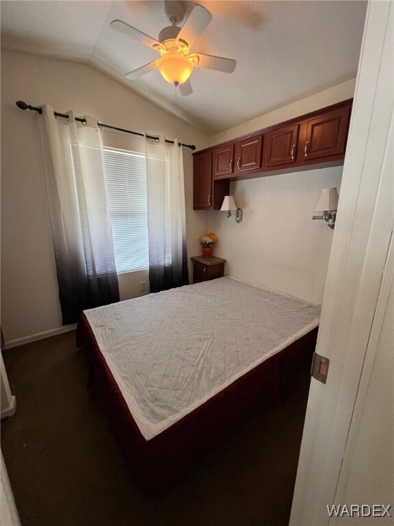 bedroom with lofted ceiling, built in cabinets, an