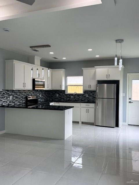 Kitchen with refrigerator, dark countertops, backsplash, plenty of natural light, and recessed lighting