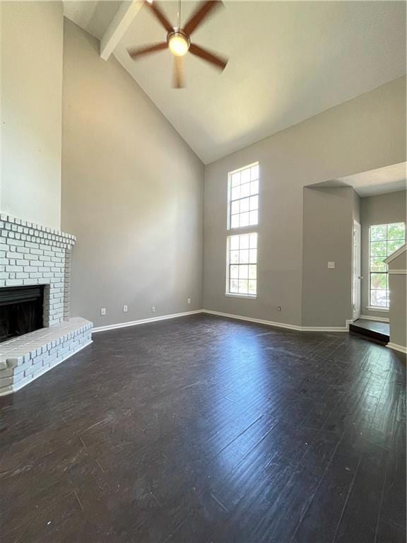 Unfurnished living room with high vaulted ceiling, a brick fireplace, dark wood-style floors, healthy amount of natural light, and beam ceiling