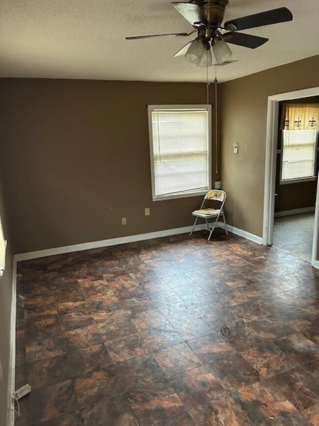 Unfurnished room featuring ceiling fan and a textu