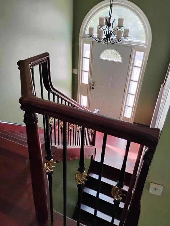 Entryway with plenty of natural light, stairs, and a chandelier