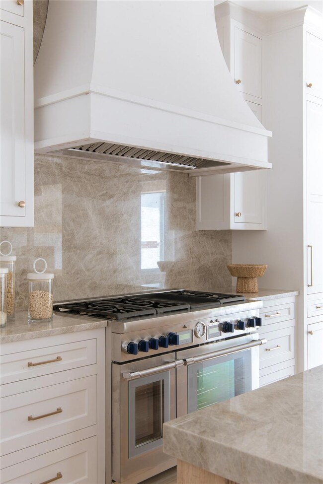 Kitchen featuring white cabinets, double oven rang
