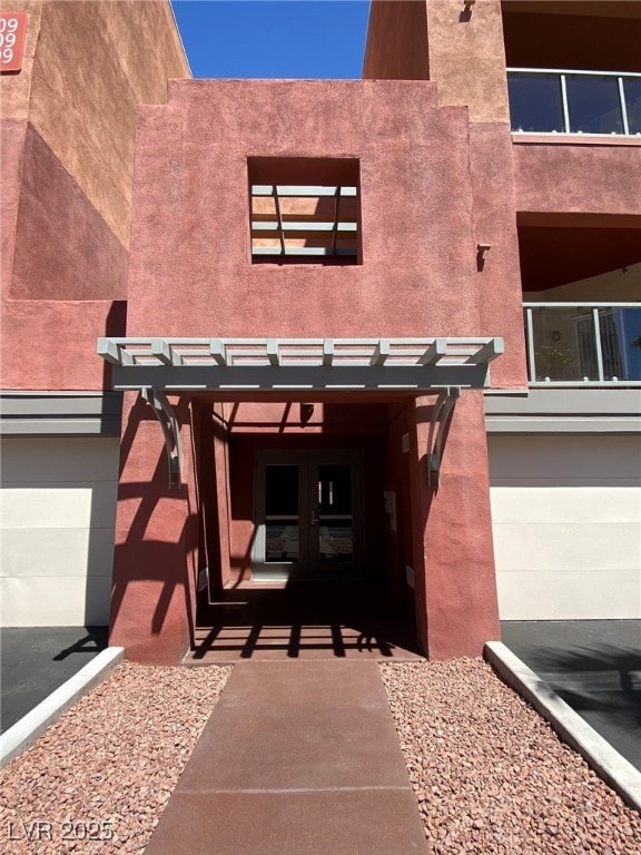 View of exterior entry featuring a pergola, french