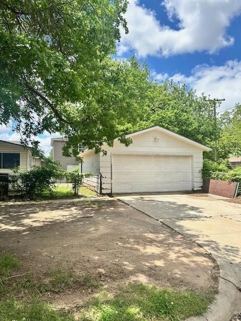 View of front of home featuring a garage and fence