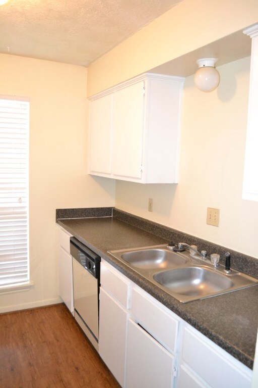 Kitchen with wood finished floors, white dishwashe