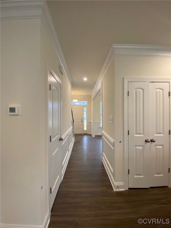 Hallway featuring crown molding, a decorative wall