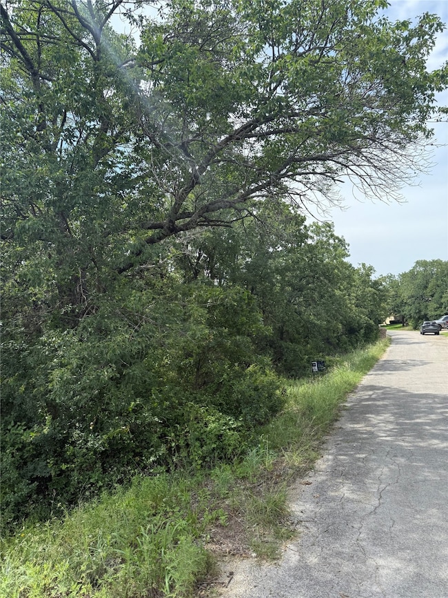View of asphalt road featuring a view of trees