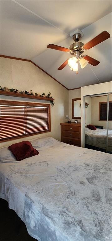 bedroom with a closet, ceiling fan, and vaulted ceiling