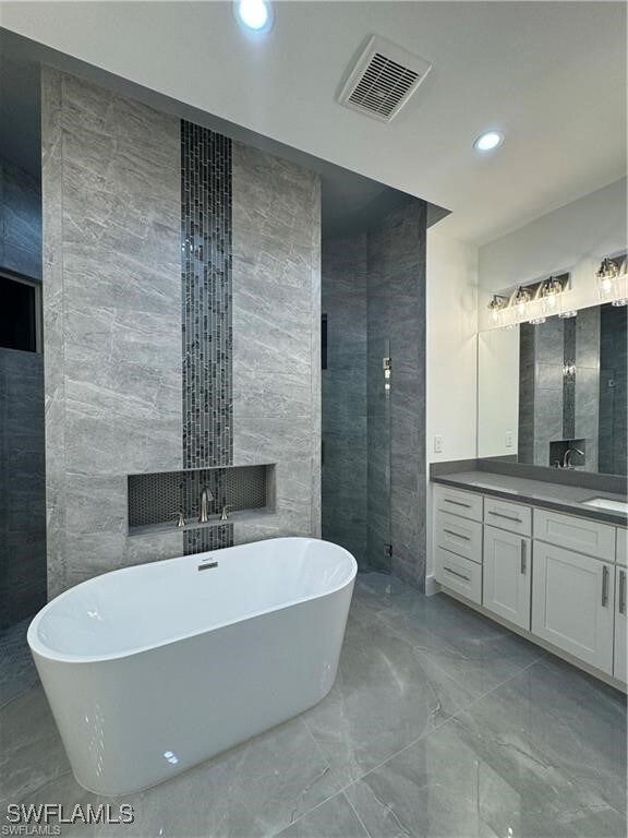 Bathroom with vanity, plus walk in shower, and tile walls
