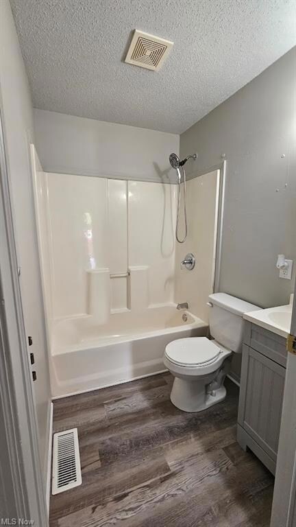 Full bathroom with dark hardwood flooring, vanity,