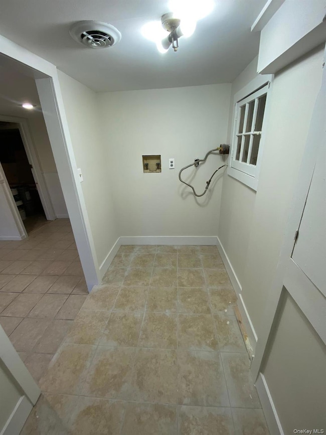 Laundry room featuring washer hookup and light tile patterned floors