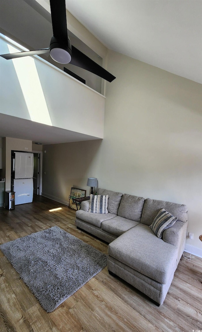 Living room with wood-type flooring and ceiling fa